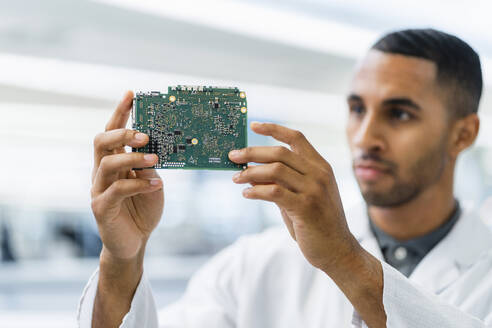 Electrical technician looking at motherboard - DIGF20164