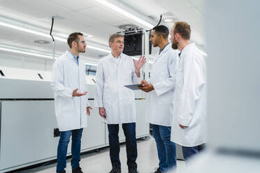 Technicians in lab coats having a meeting in electronics manufacture - DIGF20197