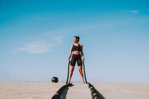 Funktionelles Training am Strand, fitte und sportliche Frau beim Sport im Freien - Konzepte zu Lifestyle, Sport und gesunder Lebensweise - DMDF00978