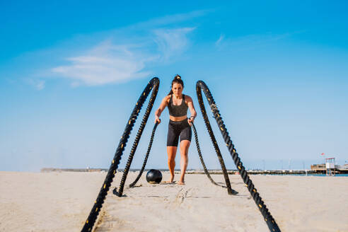 Funktionelles Training am Strand, fitte und sportliche Frau beim Sport im Freien - Konzepte zu Lifestyle, Sport und gesunder Lebensweise - DMDF00979