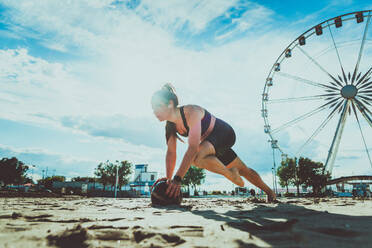 Funktionelles Training am Strand, fitte und sportliche Frau beim Sport im Freien - Konzepte zu Lifestyle, Sport und gesunder Lebensweise - DMDF00980