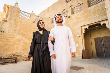 Arabian couple with traditional emirates dress dating outdoors - Happy middle-eastern couple having fun - DMDF01015