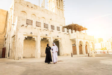 Arabian couple with traditional emirates dress dating outdoors - Happy middle-eastern couple having fun - DMDF01016