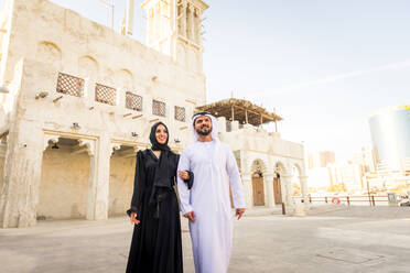 Arabian couple with traditional emirates dress dating outdoors - Happy middle-eastern couple having fun - DMDF01017