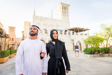 Arabian couple with traditional emirates dress dating outdoors - Happy middle-eastern couple having fun - DMDF01020
