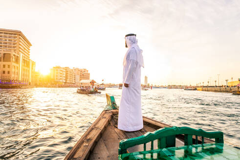 Arabian man wearing kandura on abra boat on Creek's canal in Dubai - DMDF01041