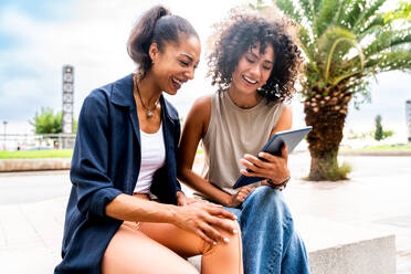 Happy beautiful hispanic south american women meeting outdoors and having fun - Black adult females friends spending time together - DMDF01046