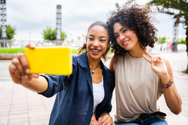 Happy beautiful hispanic south american women meeting outdoors and having fun - Black adult females friends spending time together - DMDF01053