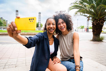 Happy beautiful hispanic south american women meeting outdoors and having fun - Black adult females friends spending time together - DMDF01056