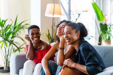 Happy beautiful hispanic south american and black women meeting indoors and having fun - Black adult females best friends spending time together, concepts about domestic life, leisure, friendship and togetherness - DMDF01086