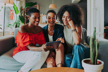 Happy beautiful hispanic south american and black women meeting indoors and having fun - Black adult females best friends spending time together, concepts about domestic life, leisure, friendship and togetherness - DMDF01089