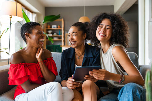 Happy beautiful hispanic south american and black women meeting indoors and having fun - Black adult females best friends spending time together, concepts about domestic life, leisure, friendship and togetherness - DMDF01094