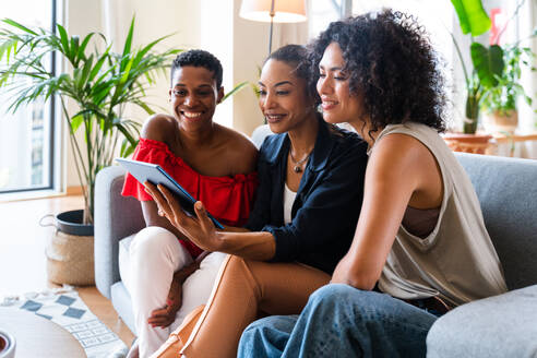 Happy beautiful hispanic south american and black women meeting indoors and having fun - Black adult females best friends spending time together, concepts about domestic life, leisure, friendship and togetherness - DMDF01097