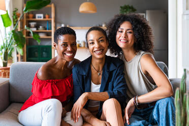 Happy beautiful hispanic south american and black women meeting indoors and having fun - Black adult females best friends spending time together, concepts about domestic life, leisure, friendship and togetherness - DMDF01100