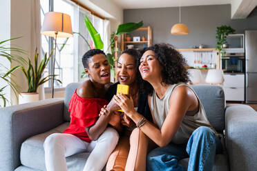 Happy beautiful hispanic south american and black women meeting indoors and having fun - Black adult females best friends spending time together, concepts about domestic life, leisure, friendship and togetherness - DMDF01106