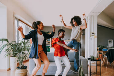 Happy beautiful hispanic south american and black women meeting indoors and having fun - Black adult females best friends spending time together, concepts about domestic life, leisure, friendship and togetherness - DMDF01115