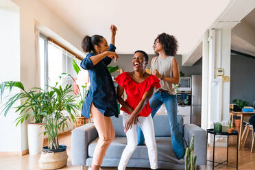 Happy beautiful hispanic south american and black women meeting indoors and having fun - Black adult females best friends spending time together, concepts about domestic life, leisure, friendship and togetherness - DMDF01116