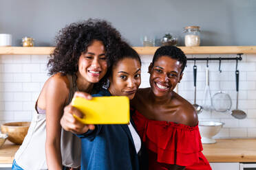 Happy beautiful hispanic south american and black women meeting indoors and having fun - Black adult females best friends spending time together, concepts about domestic life, leisure, friendship and togetherness - DMDF01133