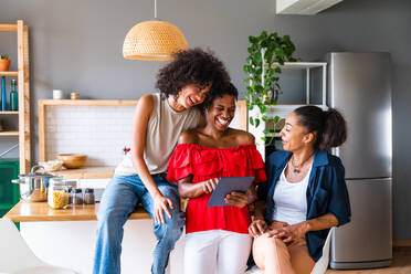 Happy beautiful hispanic south american and black women meeting indoors and having fun - Black adult females best friends spending time together, concepts about domestic life, leisure, friendship and togetherness - DMDF01153