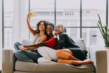 Happy beautiful hispanic south american and black women meeting indoors and having fun - Black adult females best friends spending time together, concepts about domestic life, leisure, friendship and togetherness - DMDF01177
