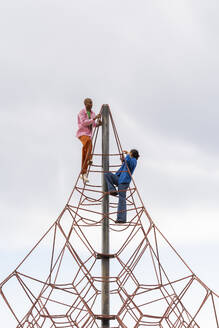 Paar klettert auf Klettergerüst im Park - AFVF09304