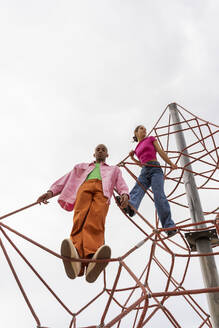 Paar verbringt seine Freizeit auf dem Klettergerüst unter dem Himmel - AFVF09312