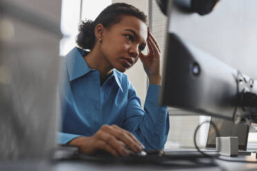 Gestresster Computerprogrammierer bei der Arbeit an einem Desktop-PC im Büro - KPEF00087