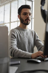 Junger IT-Fachmann bei der Arbeit am Computer - KPEF00092