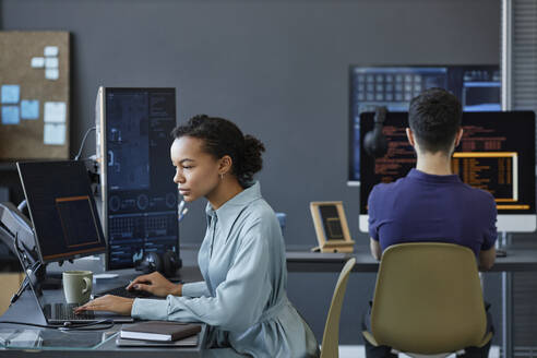 Junge Computerprogrammierer beim Programmieren am Computer im Büro - KPEF00122