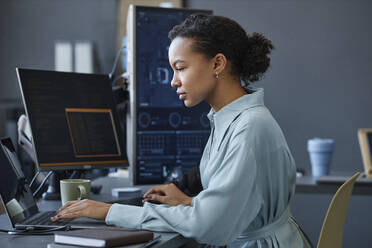 Junger Computerprogrammierer arbeitet an einem Laptop im Büro - KPEF00123