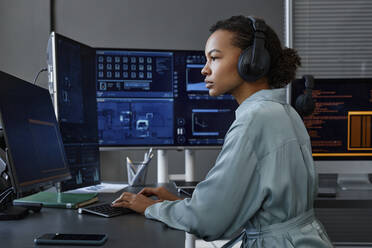 Junger Computerprogrammierer beim Programmieren und Arbeiten an einem Desktop-PC am Schreibtisch - KPEF00130