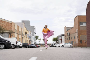 Happy woman walking on road under sky - AFVF09367