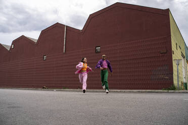 Happy couple running in front of building - AFVF09387