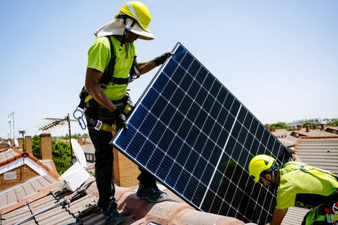 Ein Solaringenieur installiert Paneele in einem Wohngebiet und fördert nachhaltige Energielösungen für eine grünere Zukunft - JJF01116