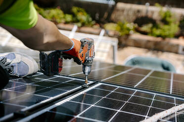 Erfahrener Solaringenieur bei der Installation nachhaltiger Solarmodule in einem Wohngebiet, um die Nutzung umweltfreundlicher Energie zu fördern - JJF01123