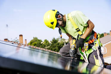 Ein erfahrener Solaringenieur bei der Installation nachhaltiger Solarzellen in einem Wohngebiet für umweltfreundliche Energielösungen. - JJF01135