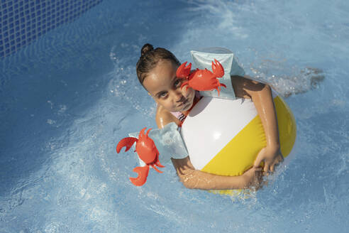 Ein junges Mädchen schwimmt fröhlich in einem kühlen und einladenden Pool in Russland und genießt die Sommersonne. - LESF00407