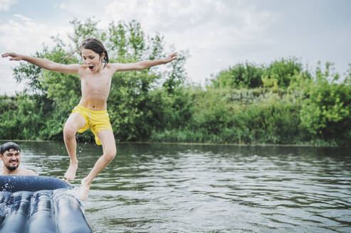 Happy boy jumping in river - ANAF01919