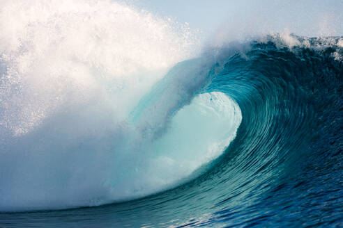 Schaumige Wellen rollen auf türkisfarbenem, dunkelblauem Meer und plätschern an einem stürmischen, hellen Tag in Französisch-Polynesien auf den Inseln Moorea und Tahiti - ADSF46365