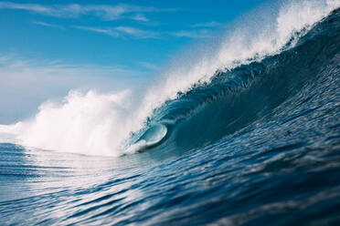 Schaumige Wellen rollen auf türkisfarbenem, dunkelblauem Meer und plätschern an einem stürmischen, hellen Tag in Französisch-Polynesien auf den Inseln Moorea und Tahiti - ADSF46369