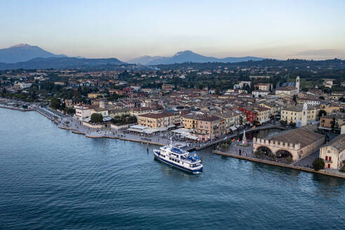 Italy, Veneto, Lazise, Aerial view of lakeshore town with ferry in foreground - AMF09951