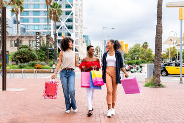 Glückliche schöne hispanische südamerikanische und schwarze Frauen, die sich im Freien treffen und Spaß haben - Schwarze erwachsene Freundinnen, die Zeit miteinander verbringen und in der Stadt zum Einkaufen gehen - DMDF01190