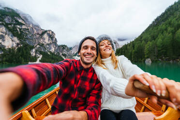 Hübsches Paar junger Erwachsener beim Besuch eines Bergsees in Prags, Italien - Touristen in Wanderkleidung haben Spaß im Urlaub während des Herbstlaubs - Konzepte über Reisen, Lebensstil und Fernweh - DMDF01217