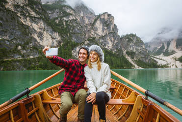 Hübsches Paar junger Erwachsener beim Besuch eines Bergsees in Prags, Italien - Touristen in Wanderkleidung haben Spaß im Urlaub während des Herbstlaubs - Konzepte über Reisen, Lebensstil und Fernweh - DMDF01231