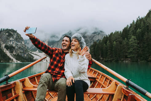 Hübsches Paar junger Erwachsener beim Besuch eines Bergsees in Prags, Italien - Touristen in Wanderkleidung haben Spaß im Urlaub während des Herbstlaubs - Konzepte über Reisen, Lebensstil und Fernweh - DMDF01232
