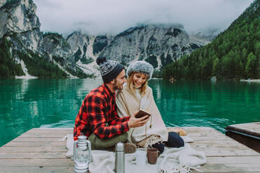 Hübsches Paar junger Erwachsener beim Besuch eines Bergsees in Prags, Italien - Touristen in Wanderkleidung haben Spaß im Urlaub während des Herbstlaubs - Konzepte über Reisen, Lebensstil und Fernweh - DMDF01254