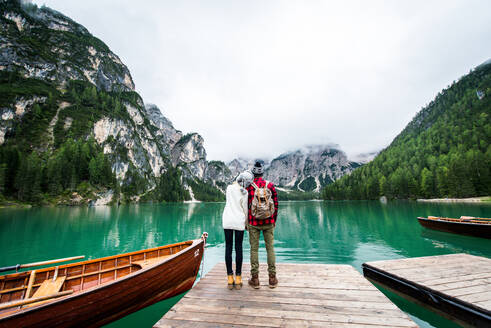 Hübsches Paar junger Erwachsener beim Besuch eines Bergsees in Prags, Italien - Touristen in Wanderkleidung haben Spaß im Urlaub während des Herbstlaubs - Konzepte über Reisen, Lebensstil und Fernweh - DMDF01263