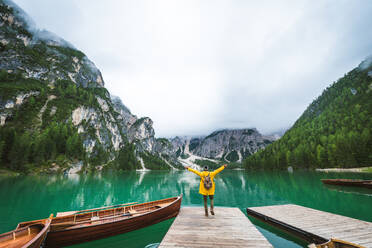 Traveler visiting an alpine lake at Braies, Italy - Tourist with hiking outfit having fun on vacation during autumn foliage - Concepts about travel, lifestyle and wanderlust - DMDF01265