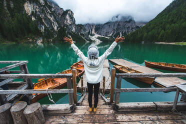 Beautiful woman visiting an alpine lake at Braies, Italy - Tourist with hiking outfit having fun on vacation during autumn foliage - Concepts about travel, lifestyle and wanderlust - DMDF01271