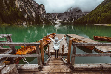 Beautiful woman visiting an alpine lake at Braies, Italy - Tourist with hiking outfit having fun on vacation during autumn foliage - Concepts about travel, lifestyle and wanderlust - DMDF01273